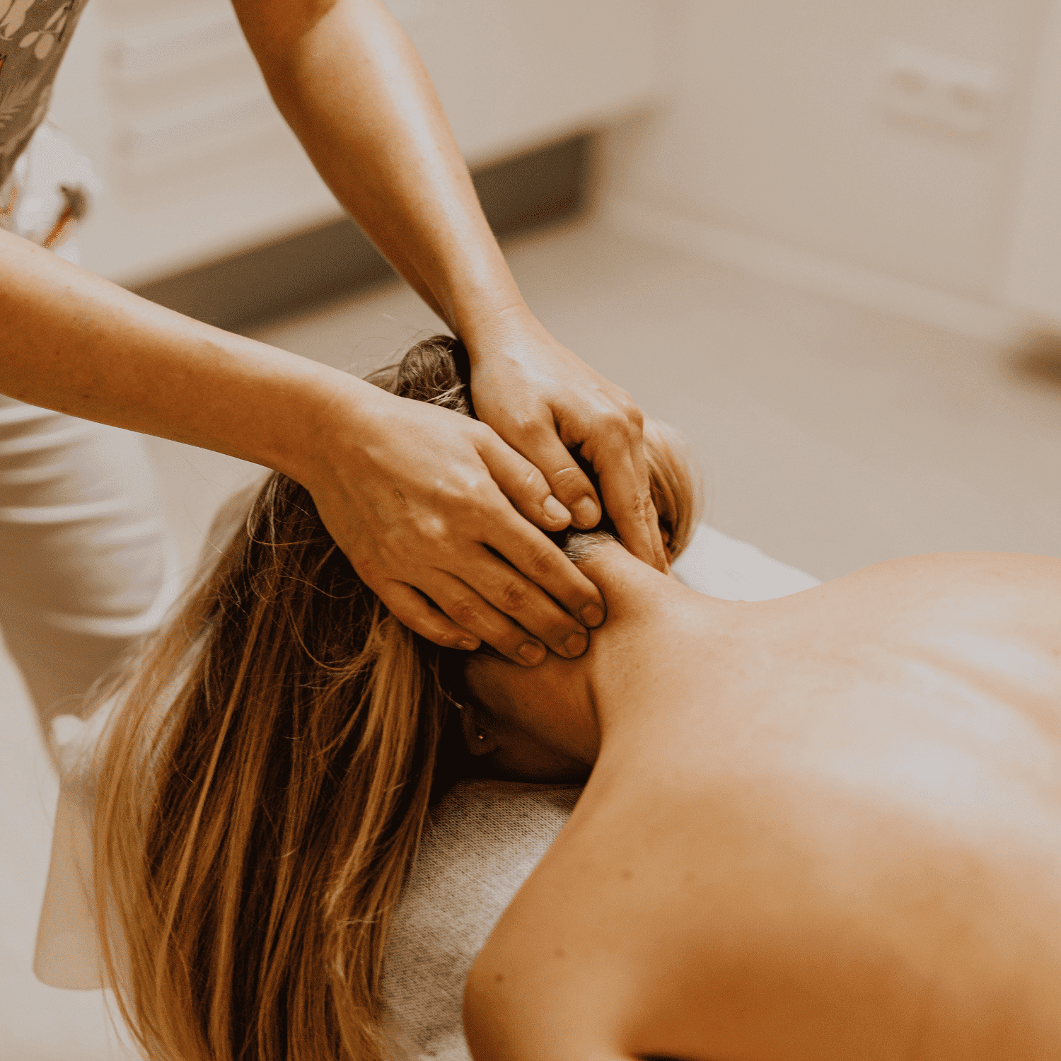 Massage therapist giving a neck and upper back massage to a relaxed client.