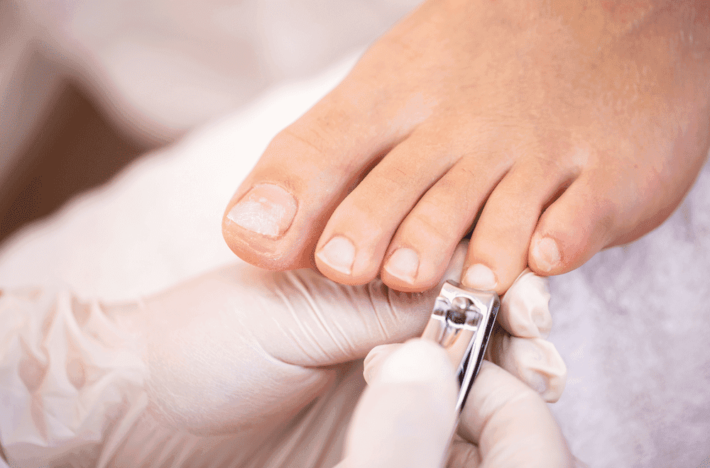 Person's toenails being carefully clipped during a pedicure session.